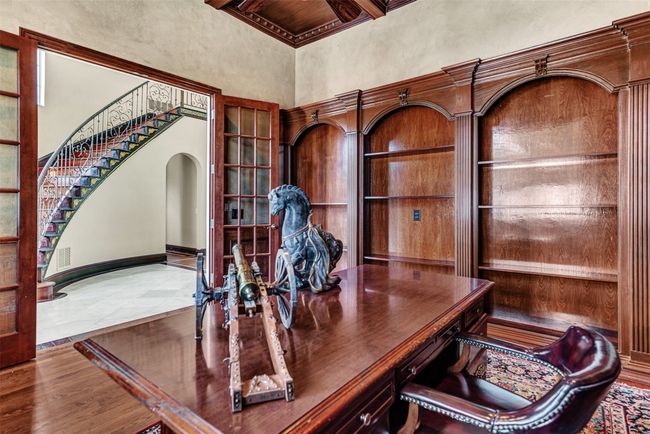 You'll never want to go back to the office after enjoying this warm and comfortable room, surrounded by bookshelves, built-in desk and rich wood paneling. | Image 27