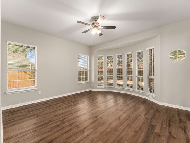 Unfurnished room with a ceiling fan, dark wood-style flooring, and a wealth of natural light | Image 6