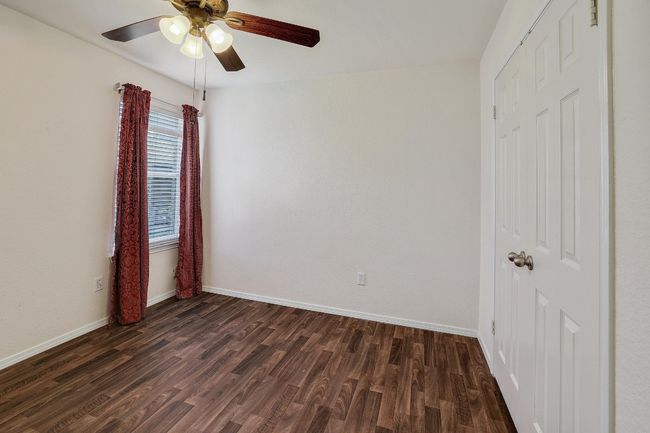 Empty room featuring dark wood-style flooring and ceiling fan | Image 20