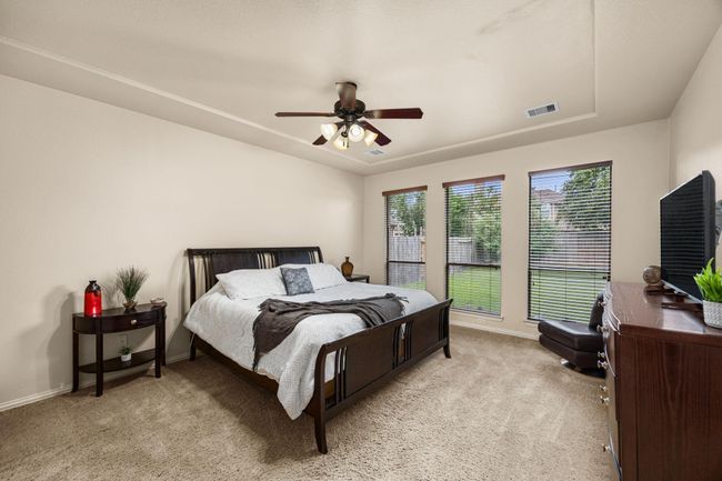 Just down a small hall, you have your primary bedroom with large door to ceiling windows. You have tray ceilings and space to have a sitting area, all within your primary bedroom. | Image 19