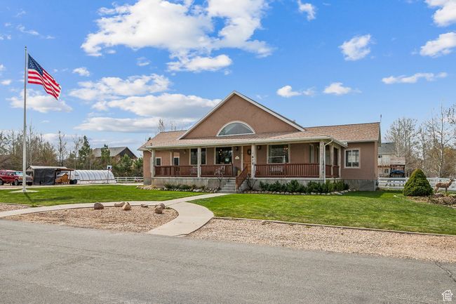 View of front facade with stucco siding, a front yard, and covered porch | Image 5