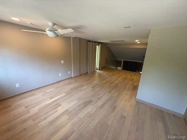 Unfurnished living room featuring lofted ceiling, recessed lighting, light wood finished floors, and ceiling fan | Image 34
