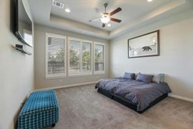 Bedroom featuring a tray ceiling, carpet floors, recessed lighting, and a ceiling fan | Image 11