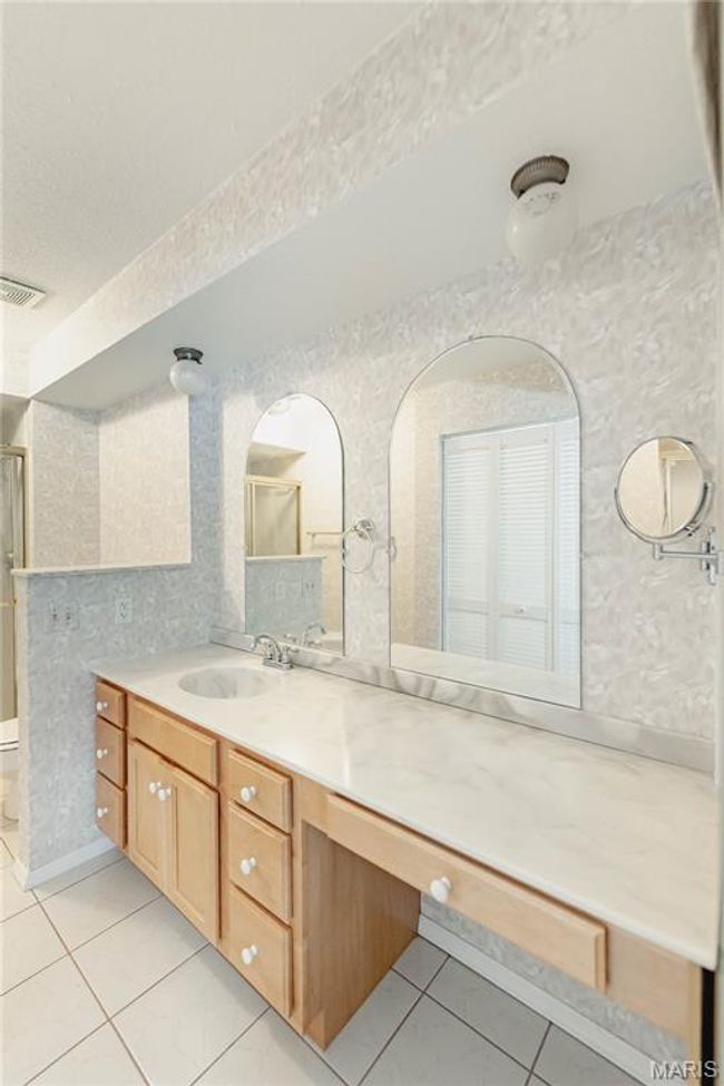 Full bathroom featuring tile patterned floors, vanity, and a shower with shower door | Image 35