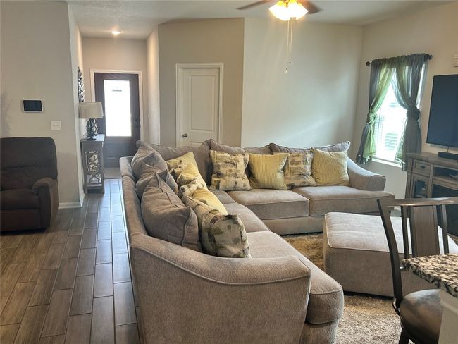 Living room with ceiling fan, dark wood-style floors, and baseboards | Image 15