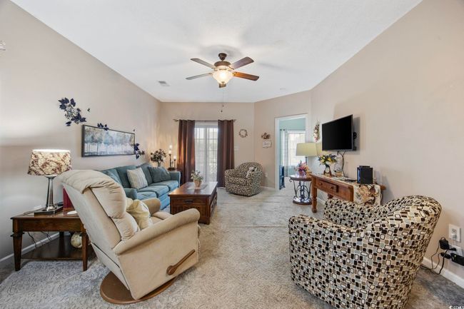 Living area with a ceiling fan, carpet floors, and baseboards | Image 12