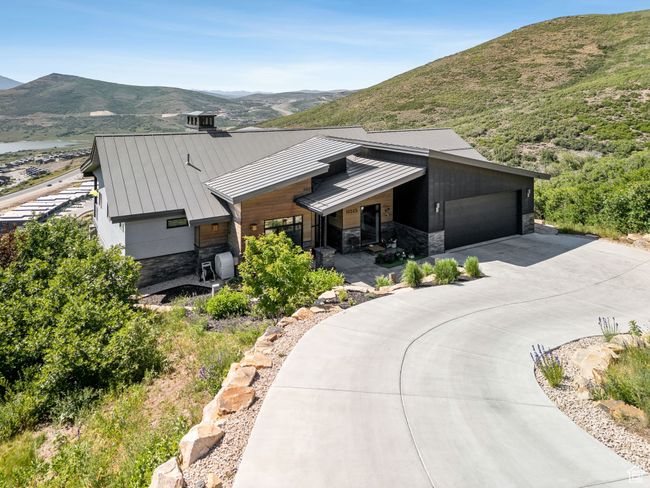 View of front of home featuring a standing seam roof, stone siding, driveway, and a mountain view | Image 7