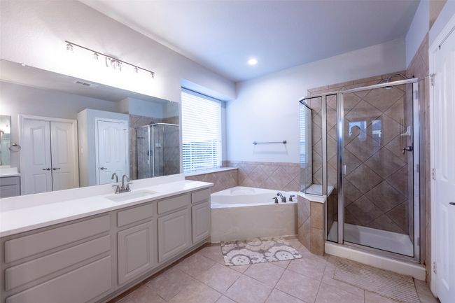 Bathroom with a bath, vanity, tile patterned flooring, and a stall shower | Image 22