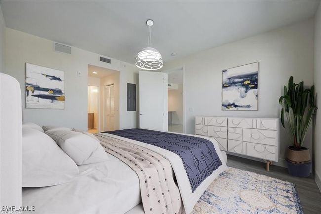 Bedroom with ensuite bath, wood finished floors, visible vents, and baseboards | Image 17