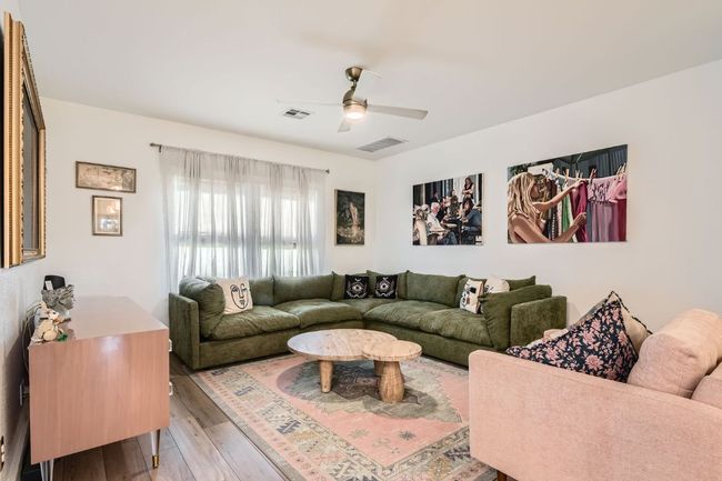 Living area featuring light wood finished floors and a ceiling fan | Image 8
