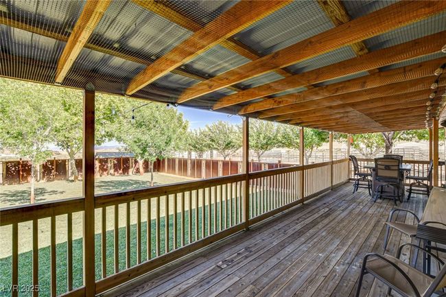 Wooden deck featuring a fenced backyard and outdoor dining area | Image 37