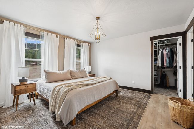 Bedroom with an inviting chandelier, a closet, a spacious closet, baseboards, and hardwood / wood-style flooring | Image 23