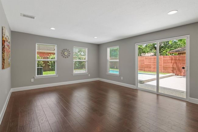 The family room features engineered wood floors, picture windows and sliding glass doors to allow for indoor/outdoor entertaining. | Image 9