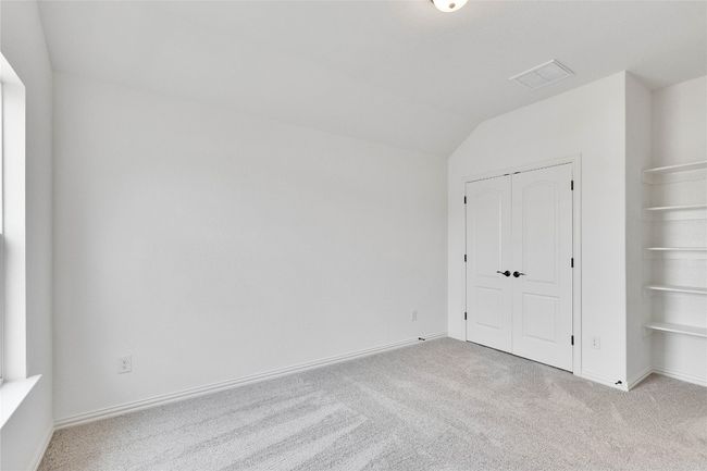 Unfurnished bedroom featuring carpet, vaulted ceiling, and a closet | Image 9
