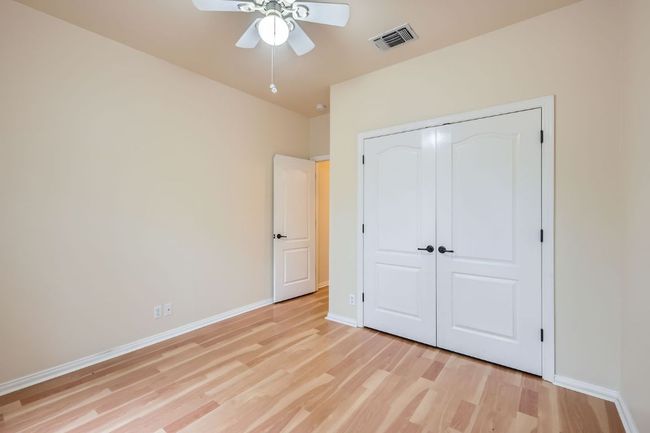 Unfurnished bedroom featuring light wood finished floors, baseboards, a closet, and a ceiling fan | Image 18