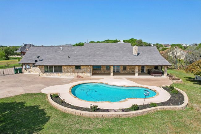 View of swimming pool featuring fence, a fenced in pool, grilling area, a lawn, and a patio area | Image 4