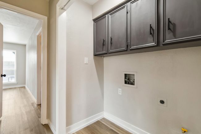 Laundry area with electric dryer hookup, light wood-type flooring, hookup for a washing machine, and baseboards | Image 16