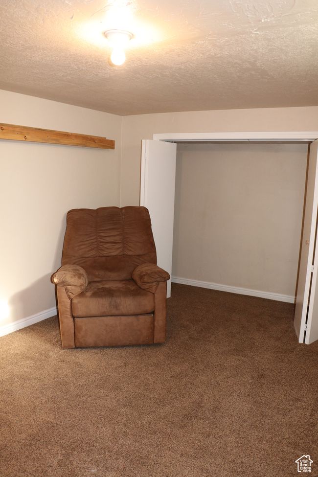 Living area with carpet flooring, a textured ceiling, and baseboards | Image 22
