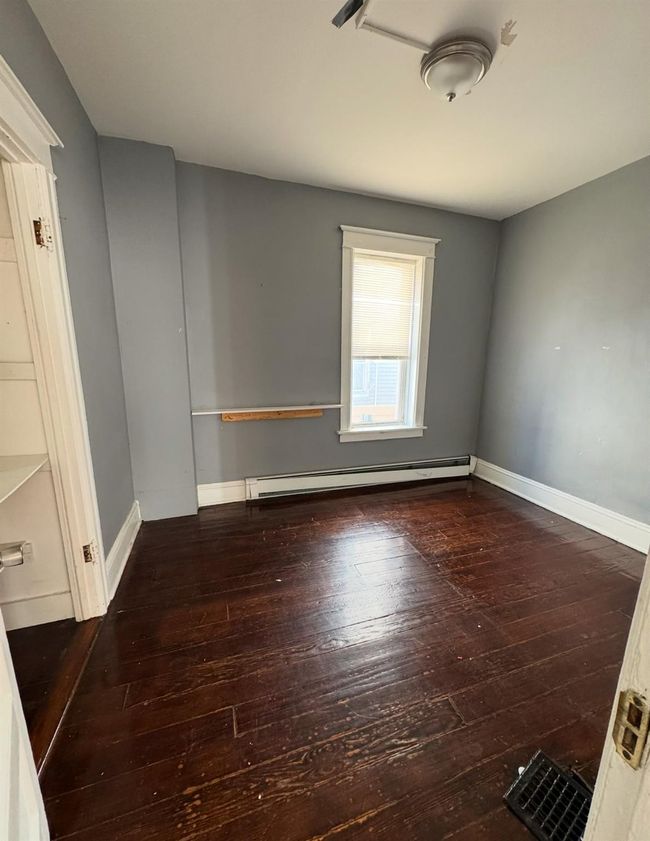 Unfurnished room with baseboard heating, baseboards, and hardwood / wood-style flooring | Image 4