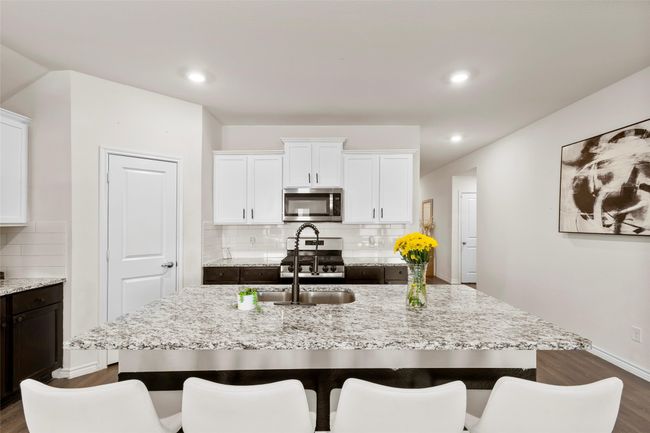 Kitchen with dark wood finished floors, backsplash, appliances with stainless steel finishes, and light stone countertops | Image 11
