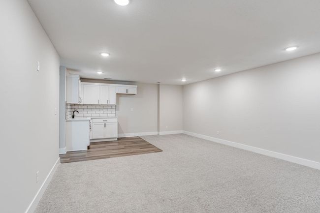 Finished basement featuring light colored carpet, recessed lighting, a sink, and baseboards | Image 23
