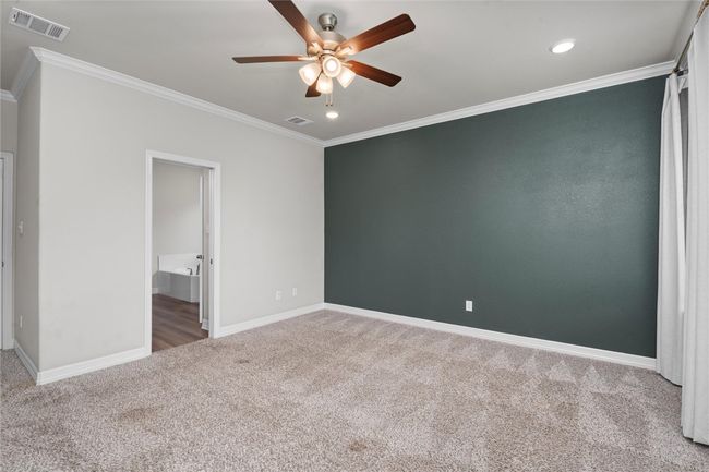 Carpeted empty room with ceiling fan, ornamental molding, baseboards, and recessed lighting | Image 15