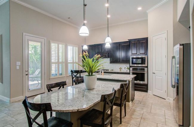Large granite island with built in breakfast table. | Image 13