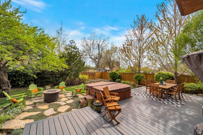 Deck featuring a fenced backyard, outdoor dining space, an outdoor fire pit, and a hot tub | Image 40
