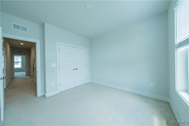 Unfurnished bedroom featuring light carpet, baseboards, and a closet | Image 35