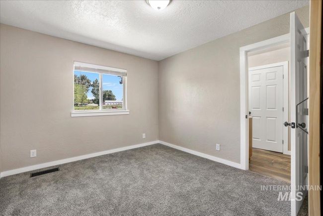 Empty room with carpet and a textured ceiling | Image 14