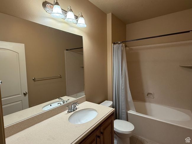 Bathroom with toilet, vanity, tile patterned flooring, and shower / tub combo | Image 15
