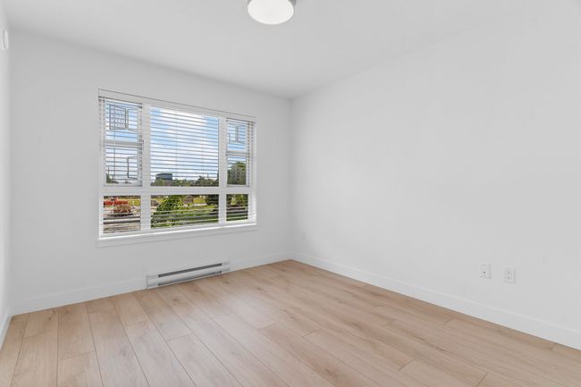Spare room featuring baseboard heating, wood finished floors, and baseboards | Image 12