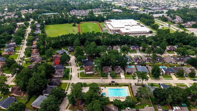 From this elevated vantage point, enjoy sweeping views of the community pool, school, track, and surrounding lush greenery—showcasing vibrant spaces thoughtfully integrated into the landscape. | Image 40