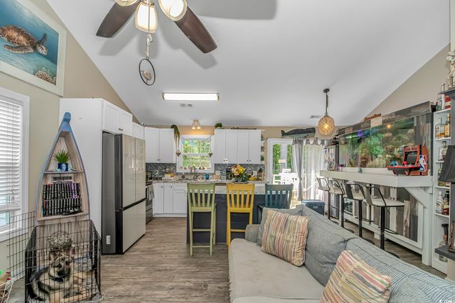 Living area featuring lofted ceiling, a ceiling fan, and light wood-type flooring | Image 7