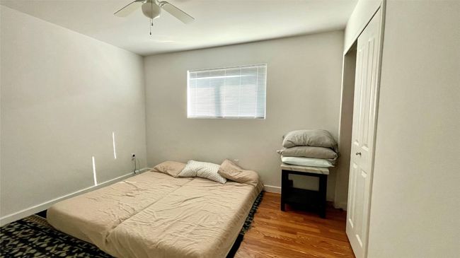 Bedroom with wood finished floors, ceiling fan, and a closet | Image 8
