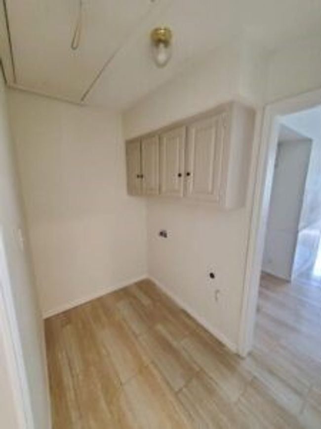 Laundry room featuring light wood-type flooring and attic access | Image 17