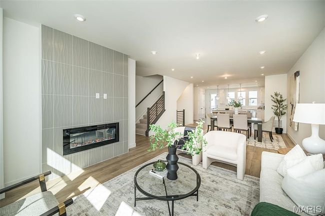 Living area with stairway, light wood finished floors, a large fireplace, and recessed lighting | Image 16