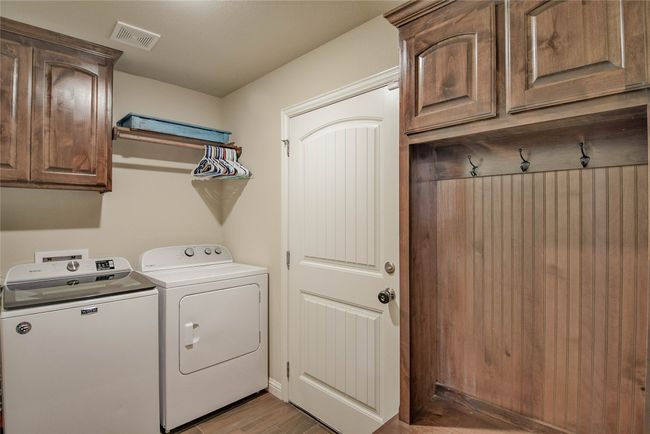 Washroom with cabinet space, washer and clothes dryer, Bench and light wood-style flooring | Image 29