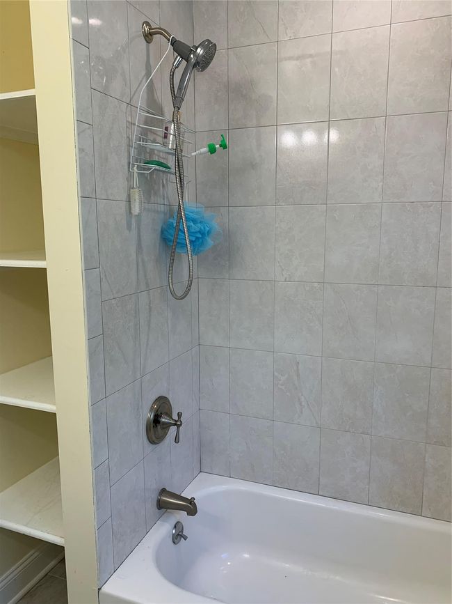 Bathroom featuring shower / bathing tub combination and shelving | Image 7