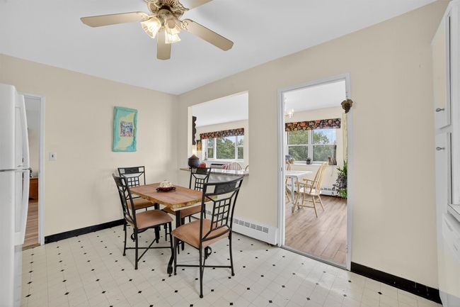 Dining area featuring a baseboard heating unit, a ceiling fan, and light flooring | Image 22