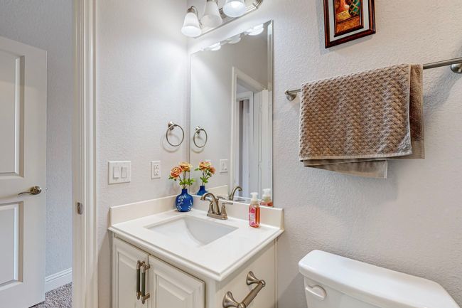 Half bath with a textured wall, toilet, and vanity | Image 26