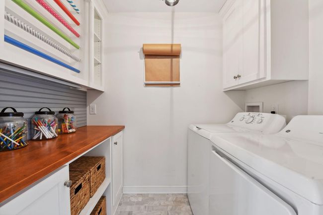 Main floor laundry room with gift wrapping station and storage. | Image 11