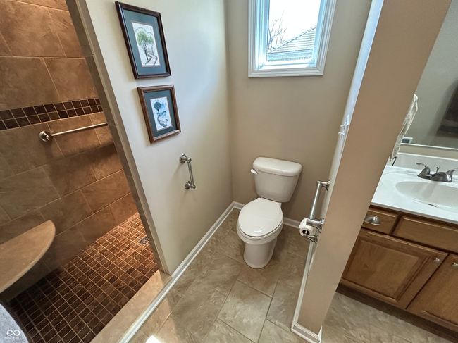 full bathroom featuring a tile shower, toilet, vanity, and baseboards | Image 17
