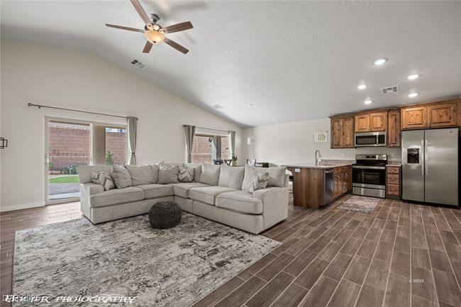 Living room featuring ceiling fan, vaulted ceiling, recessed lighting, dark wood-style floors, and baseboards | Image 18