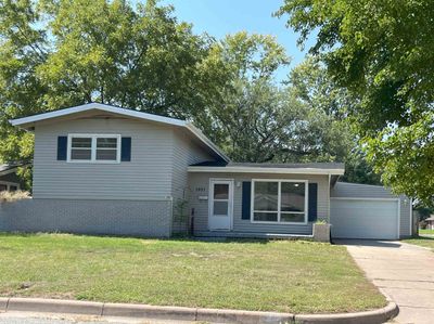 Split level home featuring a garage and a front lawn | Image 2