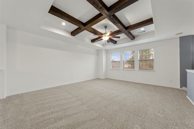 Carpeted spare room featuring visible vents, beam ceiling, baseboards, a ceiling fan, and coffered ceiling | Image 23