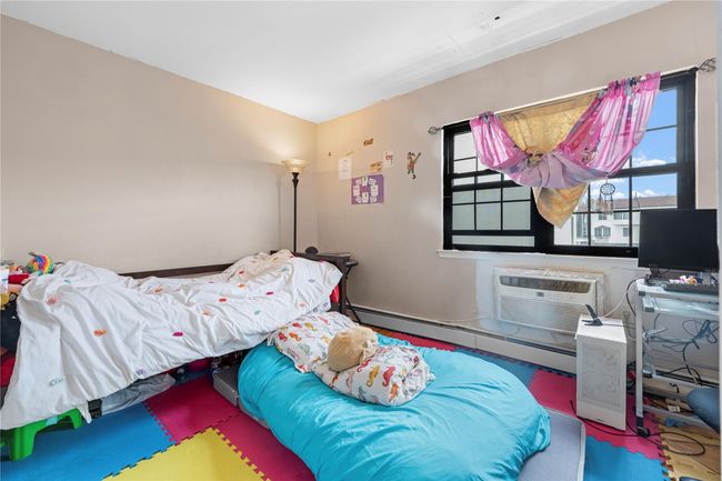 Bedroom with baseboard heating and an AC wall unit | Image 9