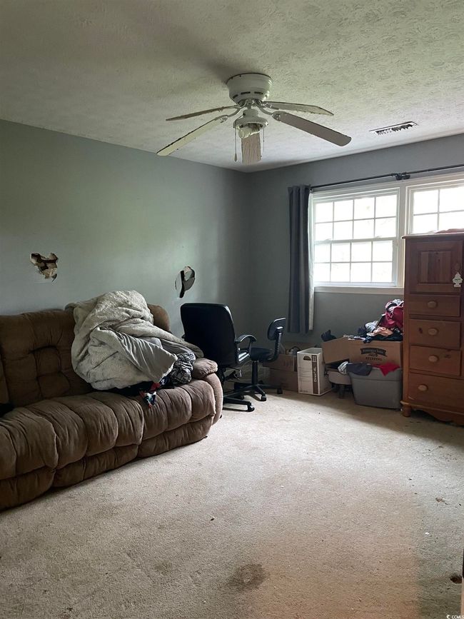 Carpeted living room featuring a ceiling fan and a textured ceiling | Image 28
