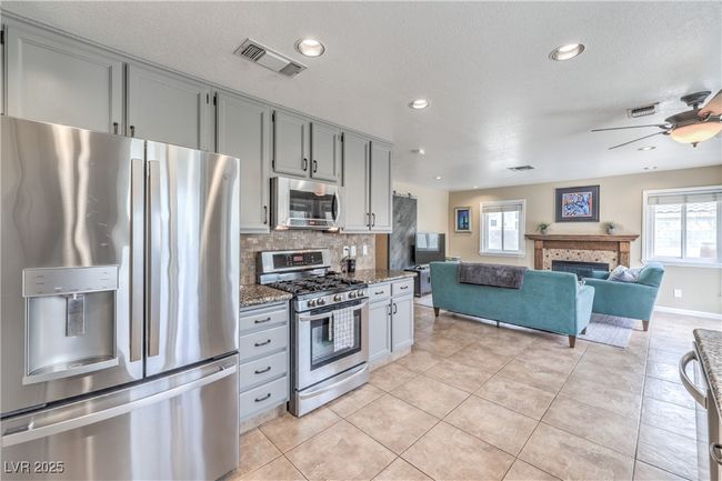 Kitchen with gray cabinets, appliances with stainless steel finishes, and decorative backsplash | Image 21