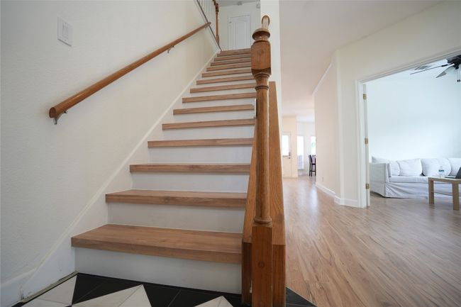 Stairway featuring ceiling fan and wood finished floors | Image 9